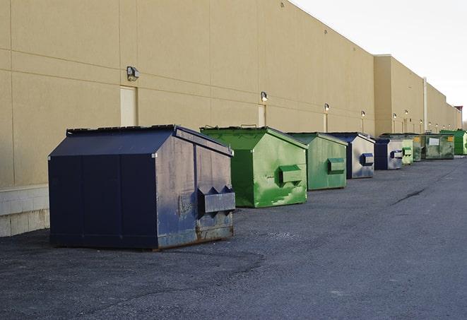 construction workers toss wood scraps into a dumpster in Butte Des Morts